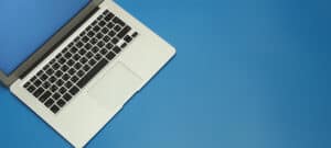 bild von einem laptop vor einem blauen hintergrund grin |