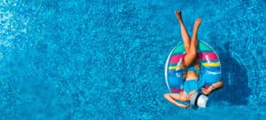 Eine junge Frau, die auf eine Luftmatratze in einem Pool liegt