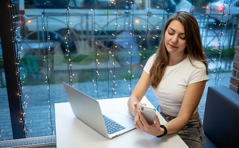 Entspannte Studentin mit Laptop und Smartphone