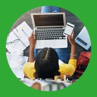Person arbeitet am Laptop und Handy